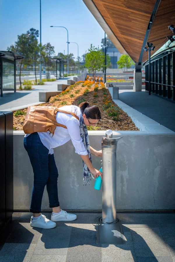 a commuter at Sydney Metro Station refilling her water bottle at an Aquafil Elegri Drinking Water Station