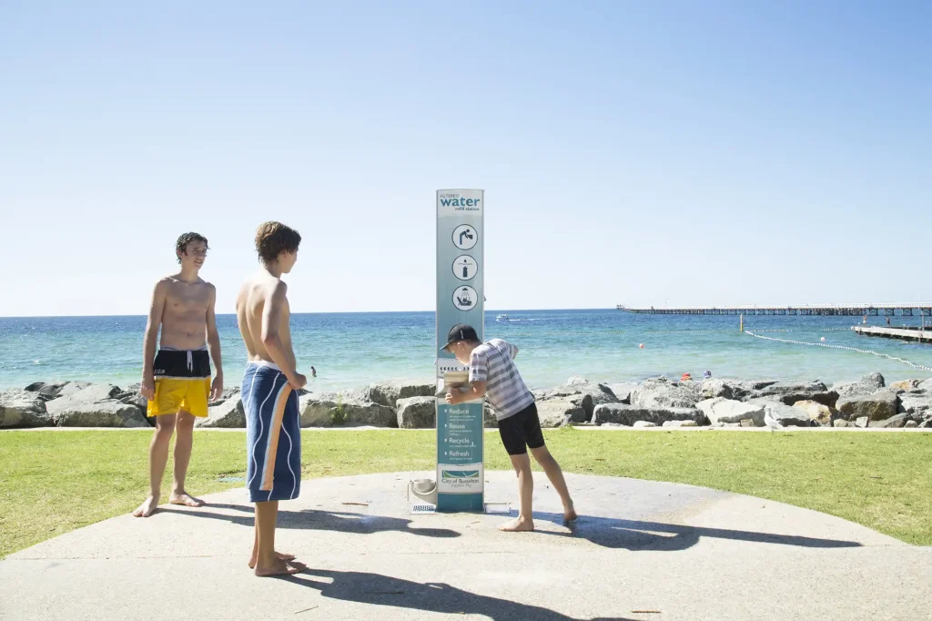 An Outdoor Shower with Drinking Fountain installed at the City of Busselton Council in Foreshore and in use by three kids