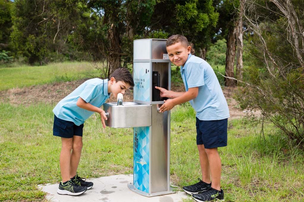 Students drinking from aquafil pulse, a drinking water station for schools