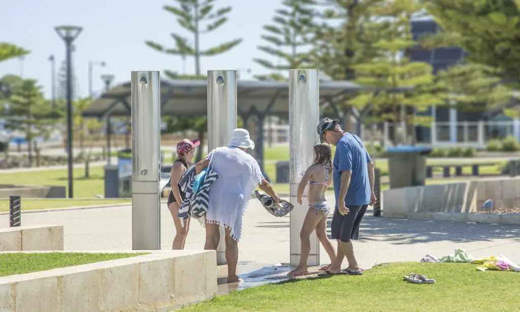 A family utilising the FlexiShower Outdoor showers with drinking fountain in Busselton