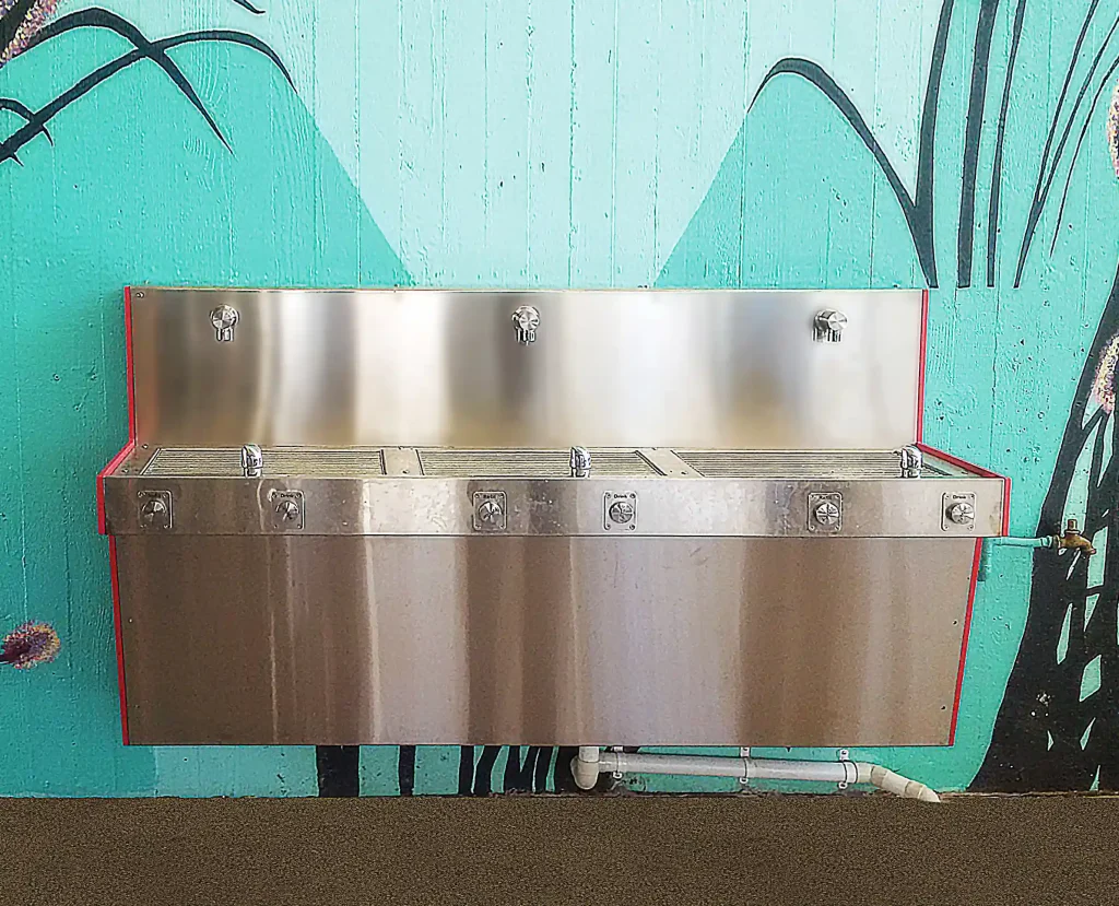 Davidson High School Drinking Trough An Aquafil Hydrobank with three drinking fountains and red HDPE panels installed on a wall with a light green mural