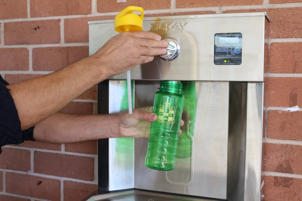 A staff refilling his water bottle with the Elkay EZH20 Drinking Water Station