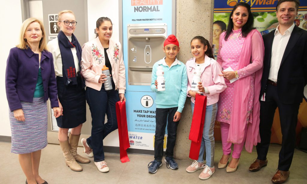 Brittany Thompson with Reema Randhawa and her Family and people from Western Sydney Local Health District and Westmead Hospital next to an Elkay Water Bottle Refilling Station
