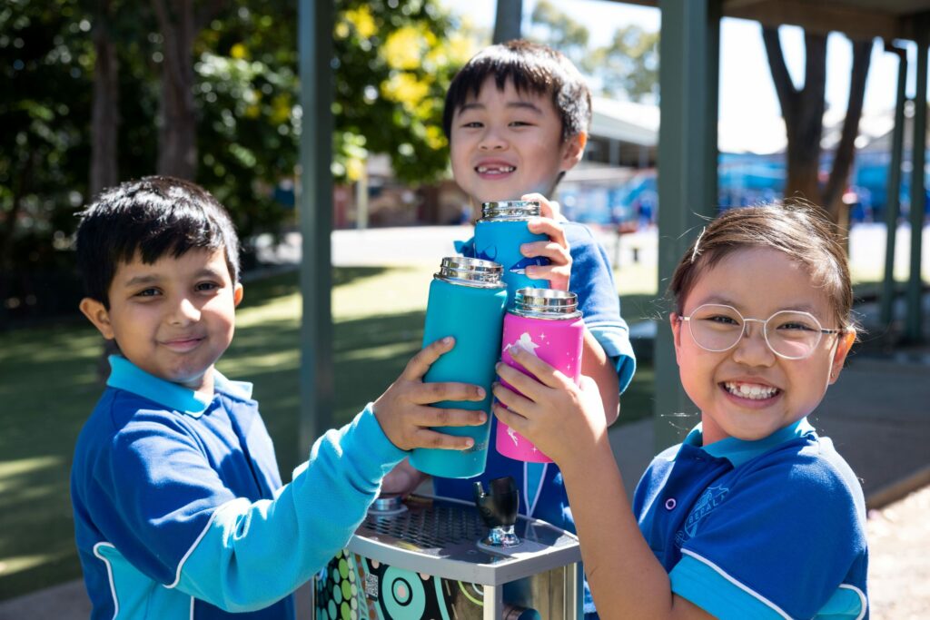 students happily holding their water bottles