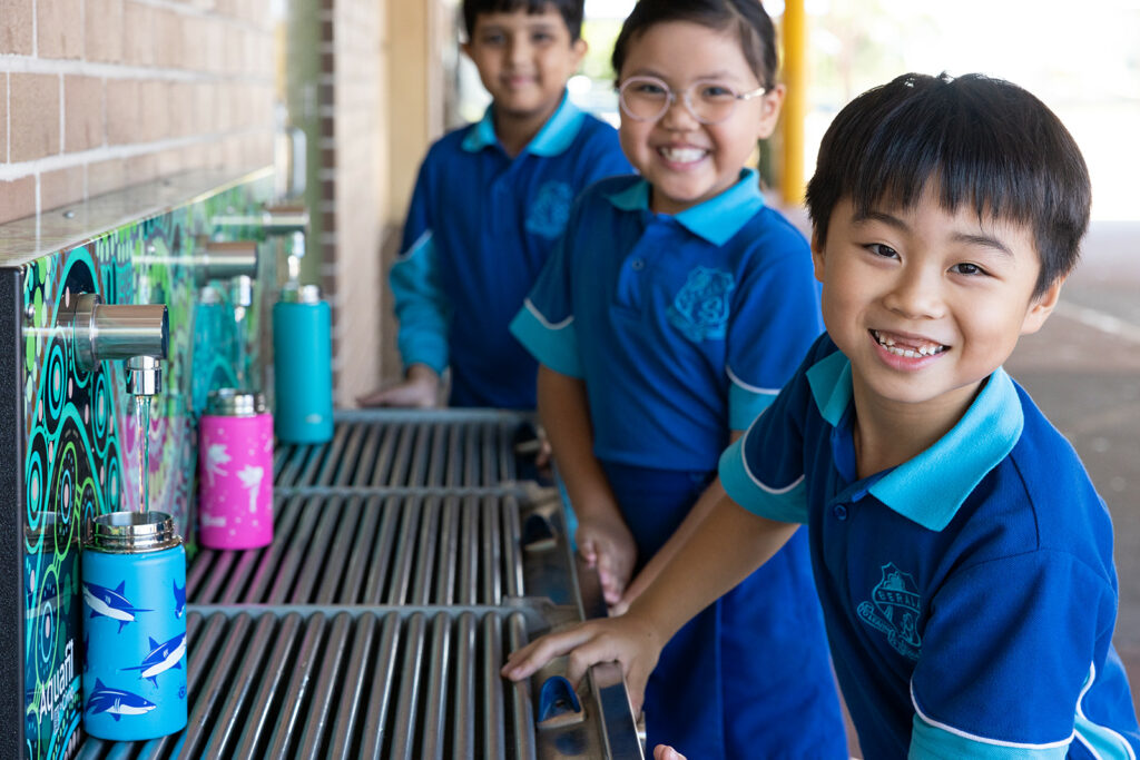 Berala Public School students quenching their thirst and refilling their water bottles using an Aquafil Solo Drinking Water Station, promoting healthy hydration within the school environment.