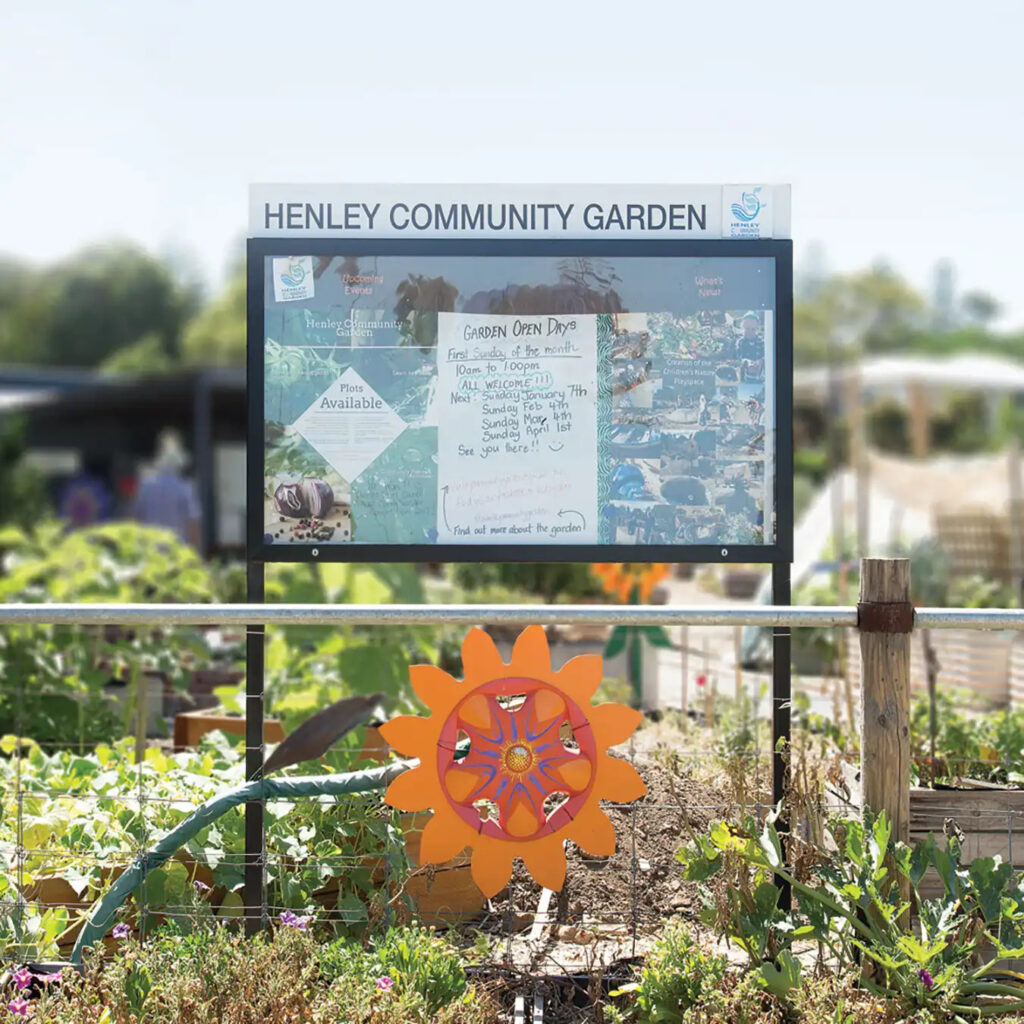 Henley Community Garden displaying a free standing community notice board with a public announcement for the Garden Opening hours