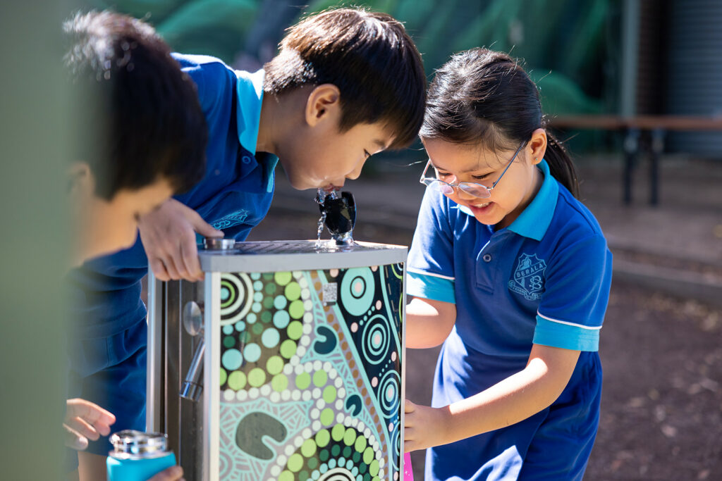 Students are refilling their water bottle at their new school Aquafil Solo, a drinking fountain and bottle refill station in Green Aboriginal Template