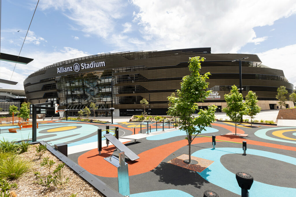 Allianz Stadium stands proudly under the sunlight, showcasing a modern architectural marvel envisioned by Cox Architecture. In the foreground, an elegant Aquafil Bold Drinking Fountain, thoughtfully specified by the designers, adds a touch of functionality and aesthetic appeal to the stadium's entrance.