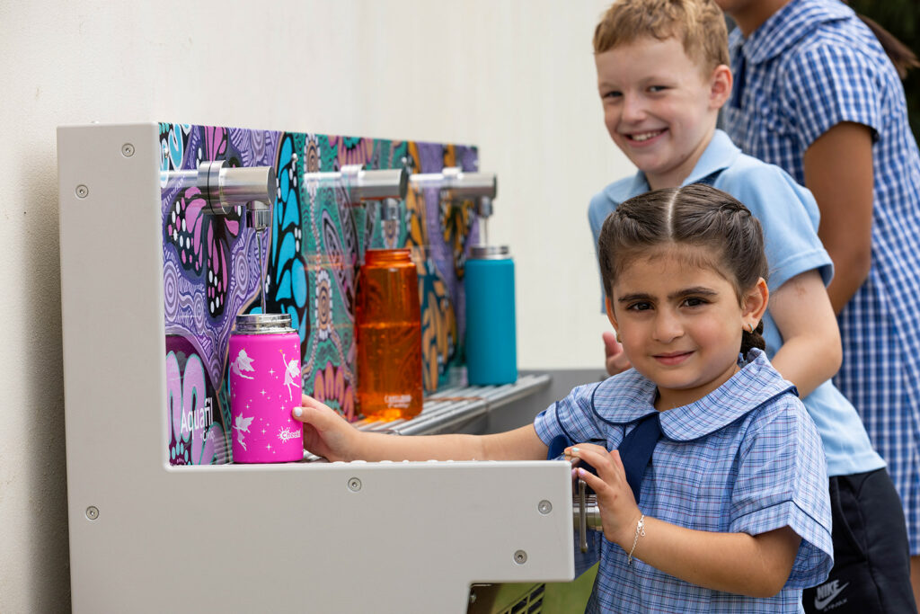 Students refilling their water bottles at Aquafil Hydrobank with new Butterflies Design Aboriginal Artwork from Luke Penrith